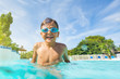 Little boy enjoying summer playing in the pool