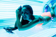 © mnelen.com - attractive beautiful girl in a swimsuit sunbathing in a horizontal sunbed under the ultraviolet rays, smiling