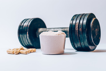 Wall Mural - Whey protein powder in a scoop next to heap of vitamin pills