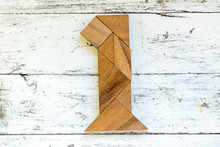 Tangram Puzzle In Number One Shape On Old White Wood Background