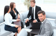 © ASDF - businessman sitting in an office on the background of business team.