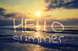 © vladimircaribb - Hello summer card. Calligraphy lettering on romantic evening and magic sunset on sandy beach of Crete, Greece. Walk on the beach during beautiful sunset.
