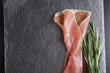prosciutto jamon ham on a stone background rosemary