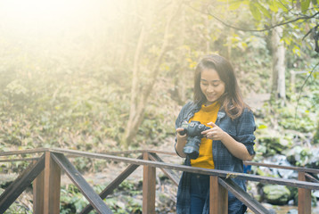 Photography and travel The girl holding the camera in humid forest zone.