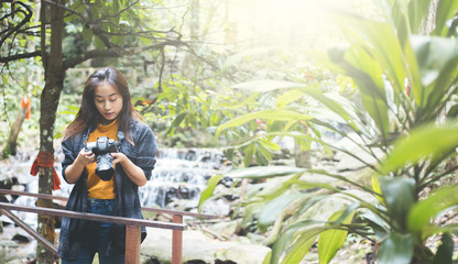 Wall Mural - Photography and travel The girl holding the camera in humid forest zone.