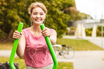 Active woman exercising on elliptical trainer.