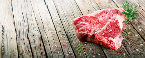 Fotografía Raw T-Bone Steak On Wooden With Rosemary And Pink Pepper