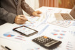 © chaiya - Businessman pen pointing graph chart and using a tablet for analyzing investment in his office.