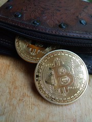 close up of two piece of bitcoin out from leather wallet