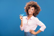 © neonshot - African american woman holding credit card in hand.