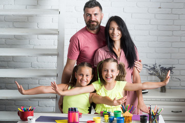 Wall Mural - Happy family smiling at table with colorful paints