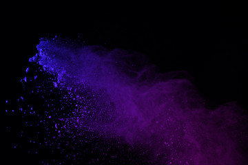 freeze motion of colorful powder explosions isolated on black background. colored dust explosive on 