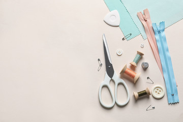 Set of tailoring accessories on light background, top view