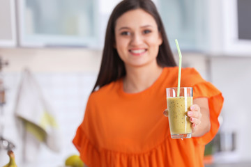 Canvas Print - Young woman with glass of tasty healthy smoothie in kitchen