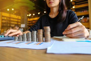 Close up of yong asian female business owner making calculations. Savings, finances and economy concept