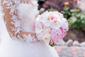 Wall Mural - Bride in rich dress holds pink wedding bouquet of orchids and peonies