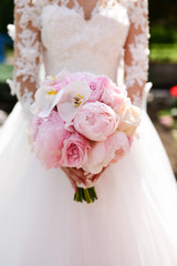 Wall Mural - Bride in rich dress holds pink wedding bouquet of orchids and peonies