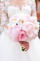 Wall Mural - Bride in rich dress holds pink wedding bouquet of orchids and peonies