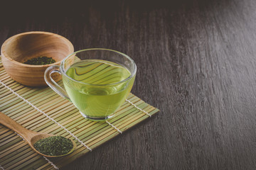 natural healthy drink, a cup of green tea on bamboo, vintage tone