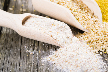 Wall Mural - raw cereal foods: millet, brown and white rice, flour, oatmeal grains on old wood background