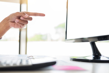 Wall Mural - businessman working together pointing screen while discussing explaining a business analysis displayed on the monitor desktop PC with colleagues in the interior of a modern office.