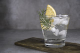 Fototapeta Kuchnia - Alcoholic drink gin tonic cocktail with lemon, rosemary and ice