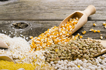 Wall Mural - corn, millet, lentil, bean and other uncooked grain foods on old wood table background