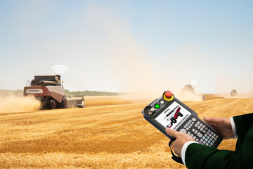 Aufkleber - Man with teach pendant device. Programming of self driving combine harvester. Internet of things in agriculture.