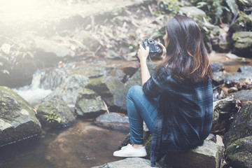 Wall Mural - Photography and travel The girl holding the camera in humid forest zone.