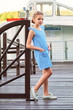 Pretty little lady girl in elegant striped blue costume dress in marine style. Fashion kid concept. Beautiful child model standing on bridge. Fashionable designer collection,summer.