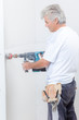 © auremar - Builder using drill with attachment to make hole