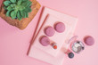 Desk on pink glasses notepad kicking pencils plant macaroons alarm clock Top View