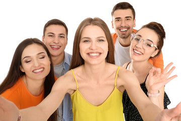 Wall Mural - Young happy friends taking selfie against white background