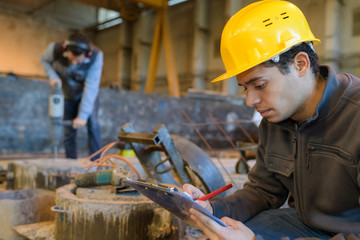 Wall Mural - man with clipboard in reflective safety vest at factory