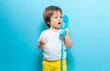 © Tierney - Toddler boy with an old fashioned phone on a blue background