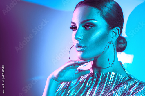 Fashion model brunette woman in colorful bright neon lights posing in