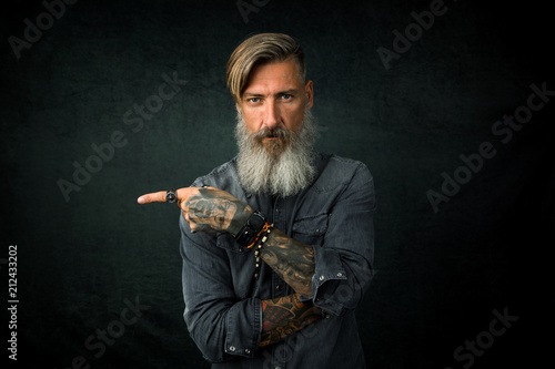 Fotografía Porträt eines bärtigen Geschäftsmannes, der mit seinem Finger Richtung rechte Se