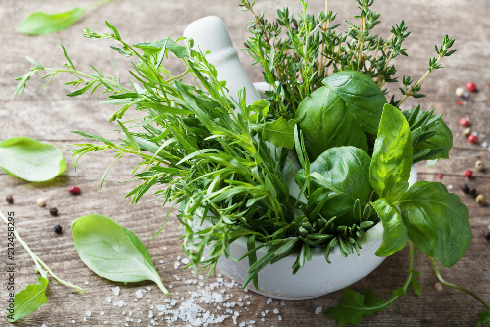 Aromatic herbs in mortar bowl. Basil, thyme, rosemary and tarragon. Fresh ingredients for cooking. - obrazy, fototapety, plakaty 