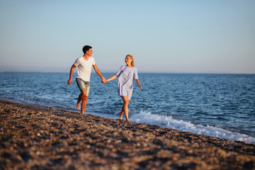 Wall Mural - Young happy couple on beach at summer vacation