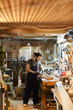 © pressmaster - Woodwork master by workbench using handtools for processing small details