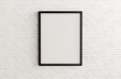 © justyle - Blank black picture frame template for place image or text inside on white brick wall.