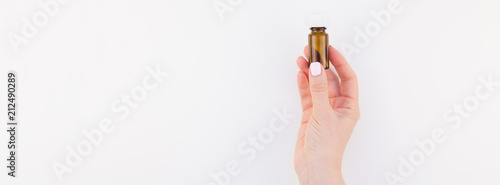 Woman hand with small glass bottle isolated Canvas Print