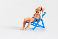 Miniature Man Relaxing Sunbathing On A Chair