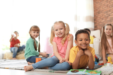 Canvas Print - Cute little children with book and blocks indoors. Learning by playing