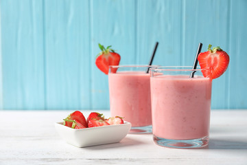 Glasses with tasty strawberry smoothie on table