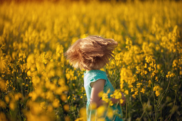 Cute portrait little child on yellow field in sunny summer day