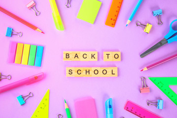 Wall Mural - School supplies on violet background ready for your design. Flat lay. Top view.