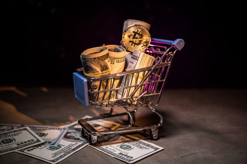 close up view of little shopping trolley full of coins isolated on brown.Gold coins in shopping online cart isolated on brown background,Saving Money Concept. Shopping trolley or cart with coin