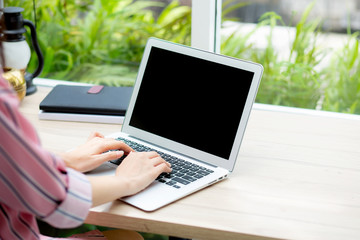 Wall Mural - Beautiful of portrait asian young woman working online on laptop computer sitting at coffee shop, professional female freelancer using notebook with connect to internet for distance job.