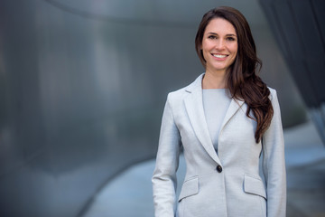 Smiling beautiful commercial model business woman professional entrepreneur in a suit with copy space